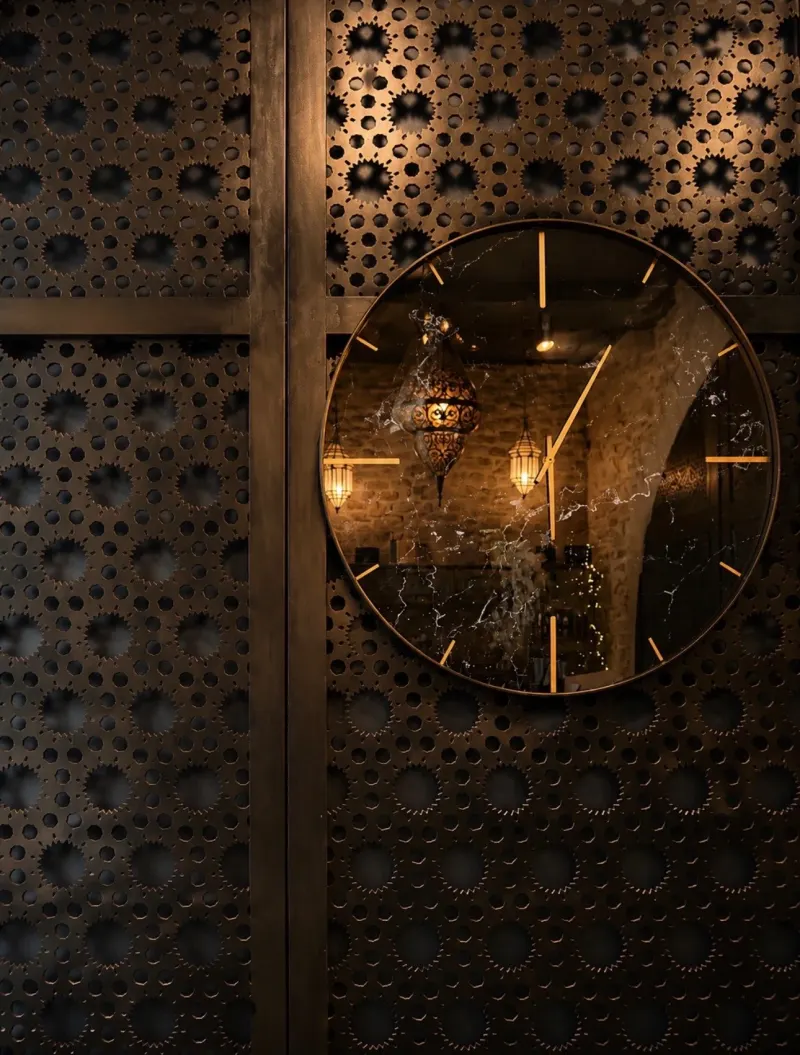 A round clock on a pierced metal screen