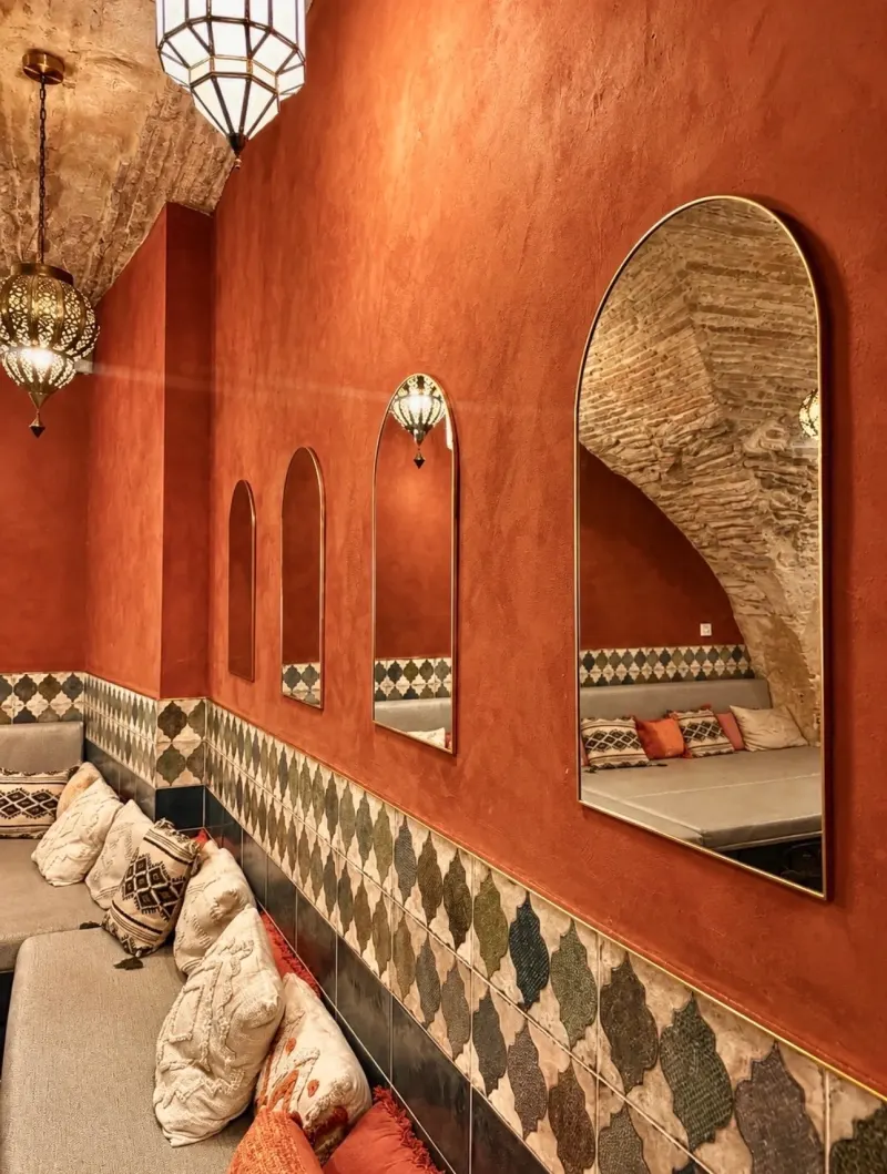 Arched mirrors and zellige tiles on the ochre walls of the lounge